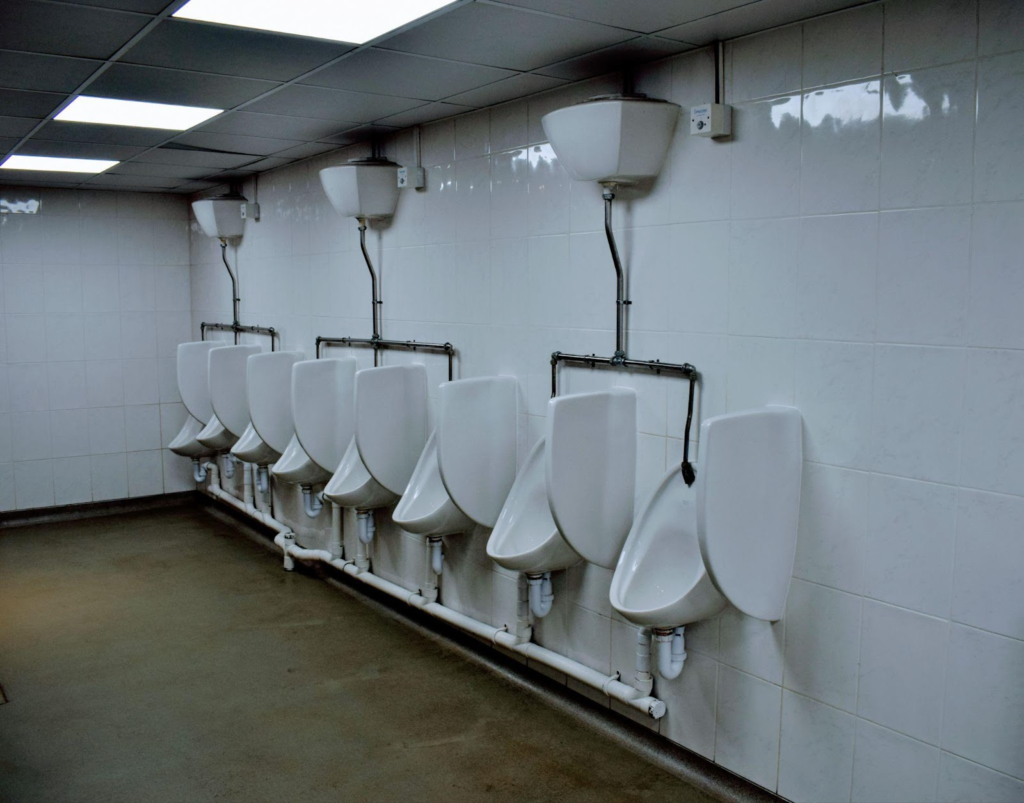 A row of white urinals in a public restroom.

