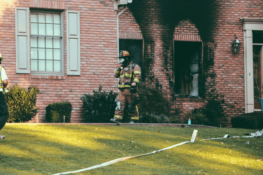 firefighter covering his nose wearing hat 