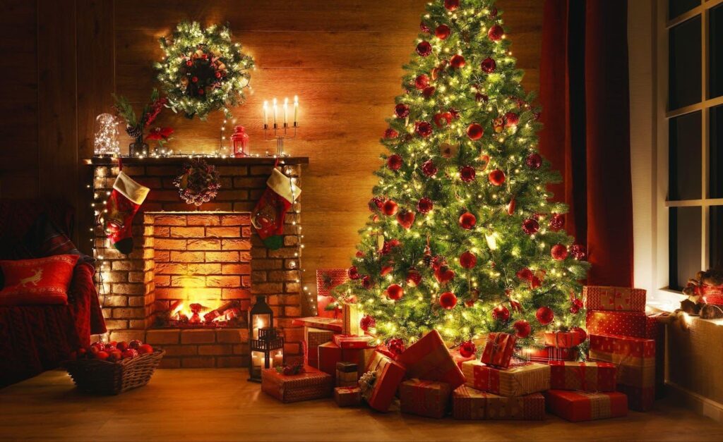 A festive Christmas tree with ornaments and gifts in a warm room with a glowing fireplace