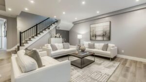 A bright living room with white furniture and a staircase, creating an inviting atmosphere