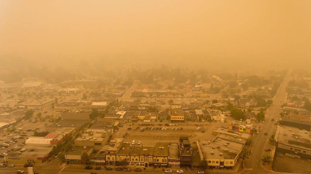 A city view with a smoky haze suggesting environmental issues or a fire impacting the clarity of the skyline