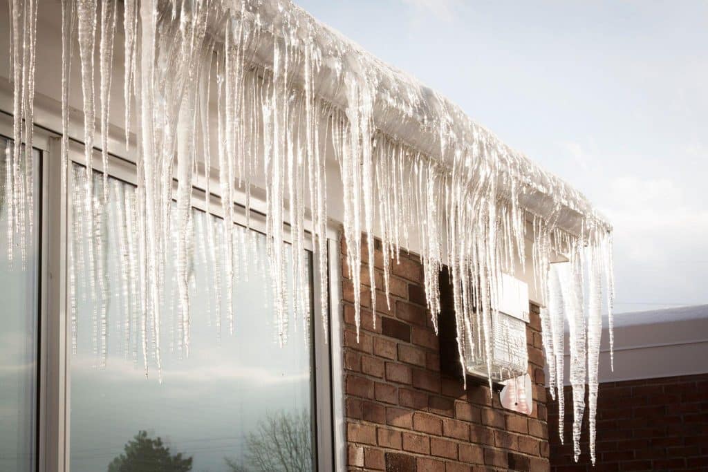 A building exterior featuring icicles hanging from the roof indicating cold weather conditions